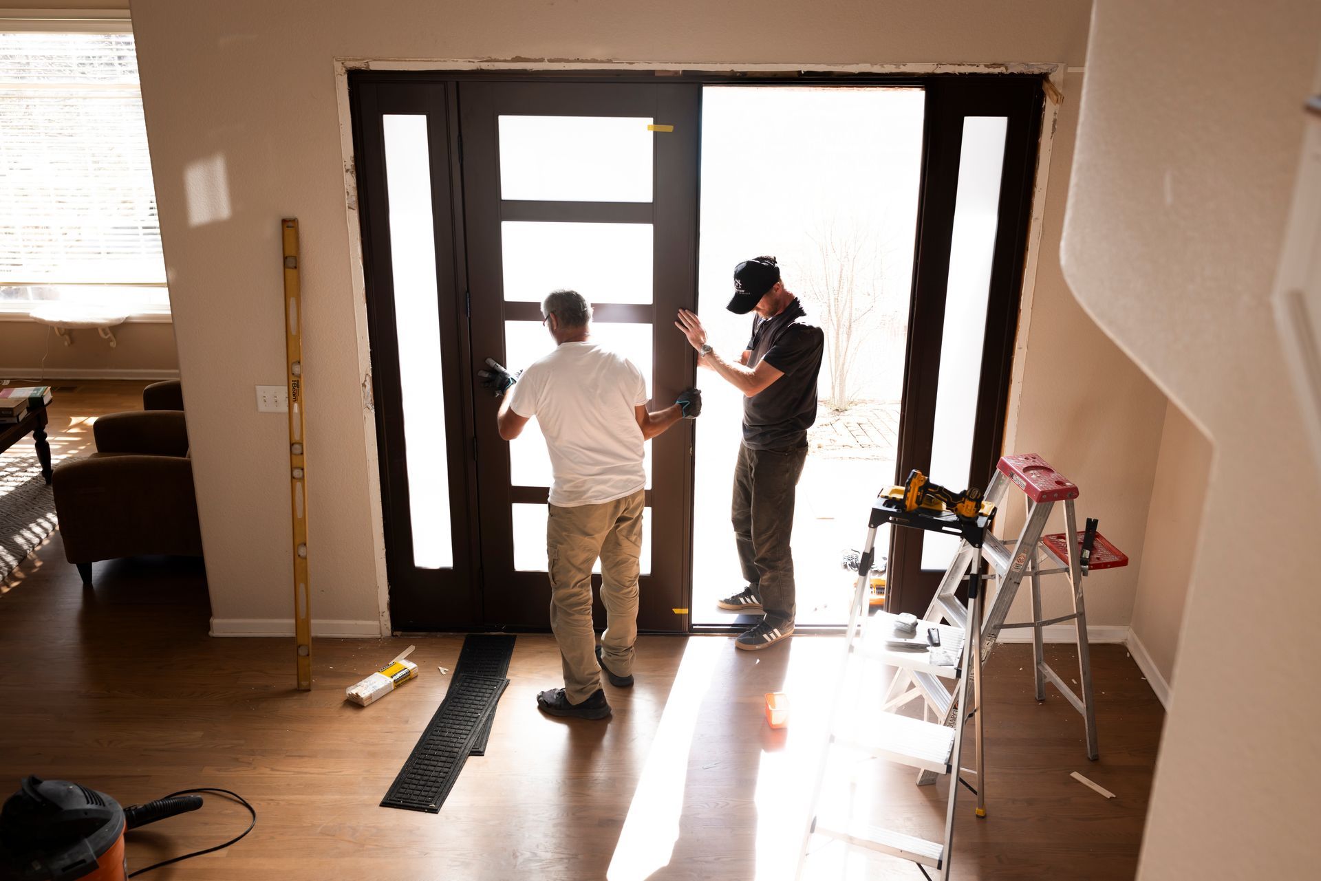 Black toolbox open, filled with hammers, staple gun, and other tools.