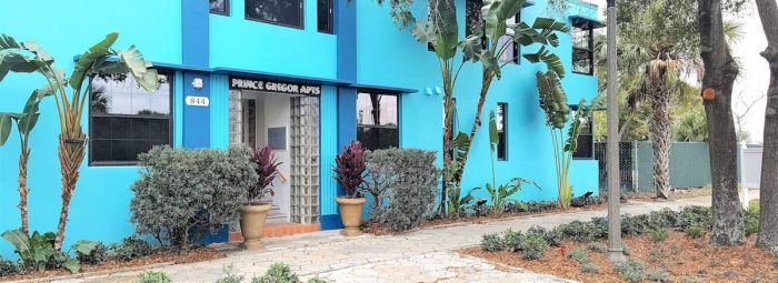 Two-story, bright blue apartment building