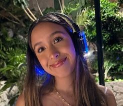 Una joven que lleva auriculares sonríe para la cámara.