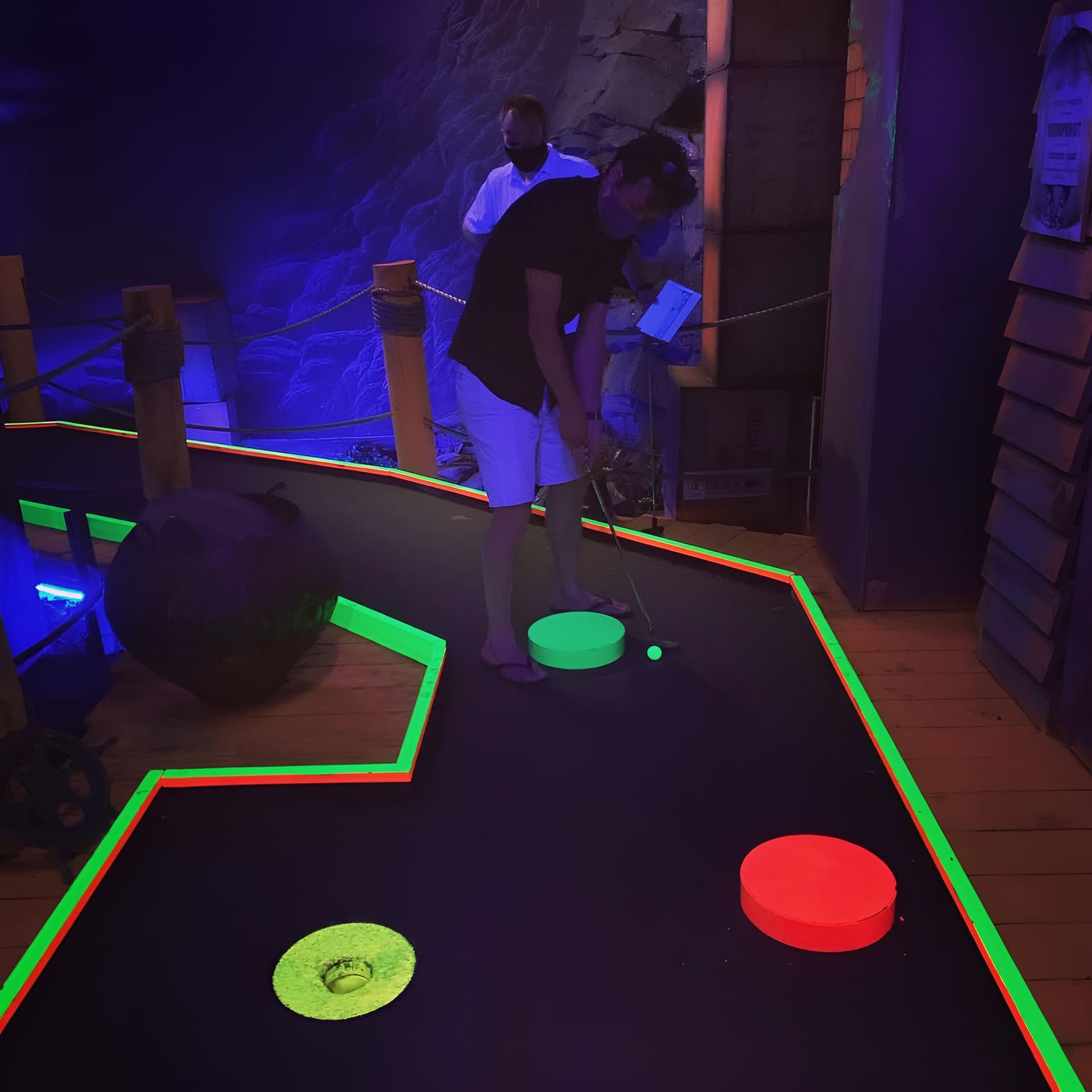A Man is Playing Glow in the Dark Mini Golf — Gold Rush Mini Golf in Warrenheip, VIC