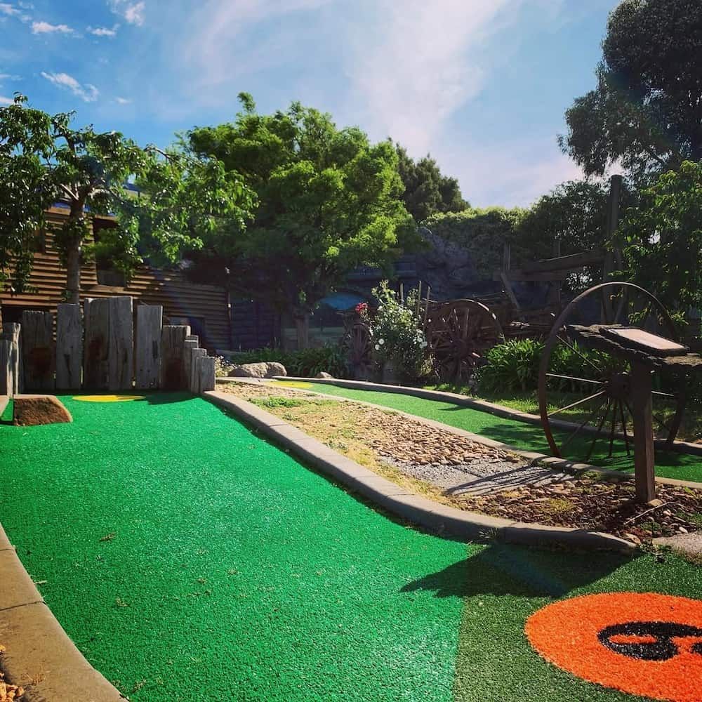 A Green and Orange Golf Course With the Letter G on It — Gold Rush Mini Golf in Warrenheip, VIC