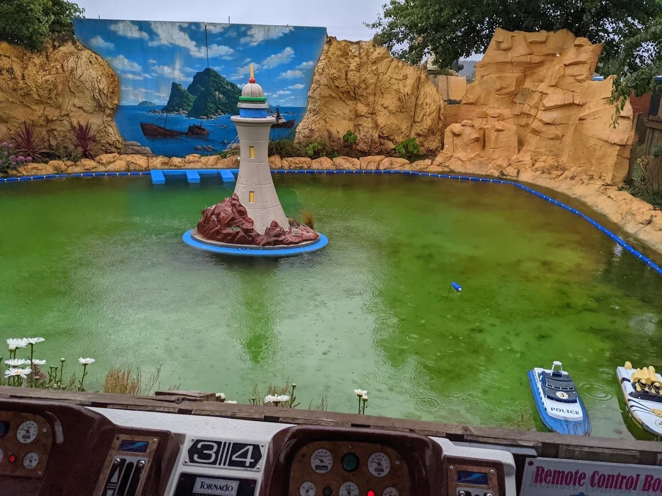 A Small Pond With A Lighthouse Statue And Small Boat — Gold Rush Mini Golf in Warrenheip, VIC