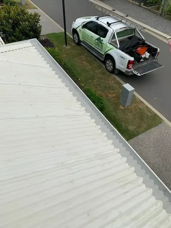 A White Truck Is Parked On The Side Of The Road Next To A White Roof — Gutter Guard In Lake Cathie, NSW