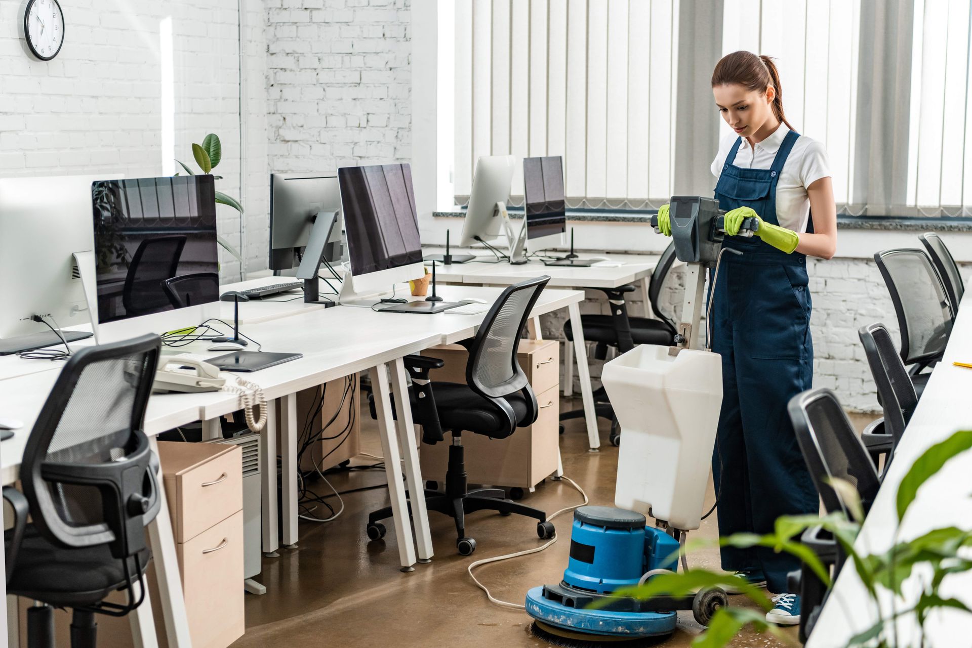 a woman is cleaning an office with a vacuum cleaner