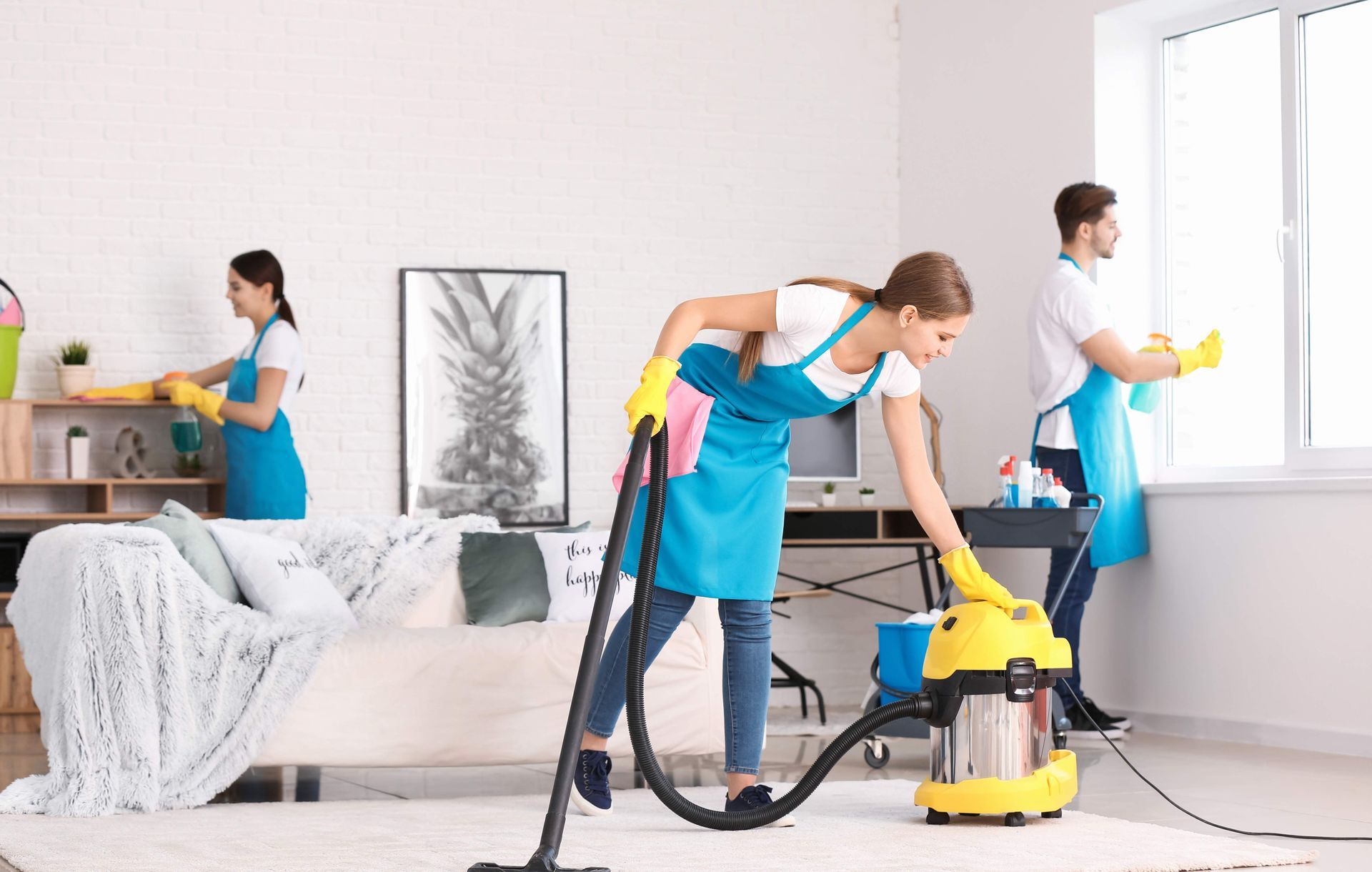 a group of cleaners are cleaning a living room .
