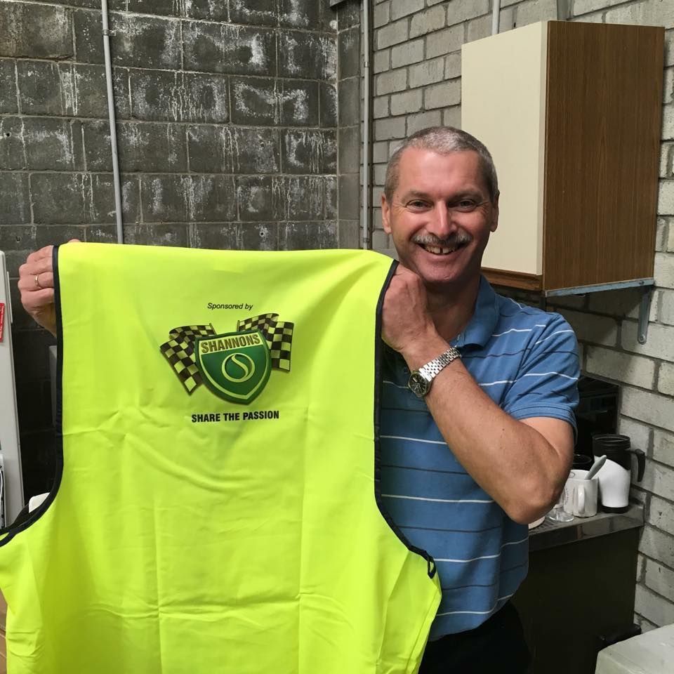 Man In A Blue Shirt Holding A Yellow Vest That Says Pima On It — Accolades Awards Hunter Valley In Maitland, NSW