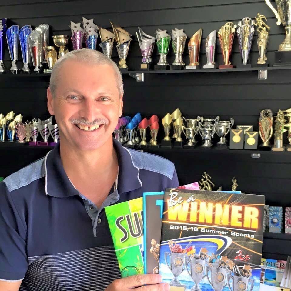 Man Holding A Book With Winner Sign — Accolades Awards Hunter Valley In Maitland, NSW