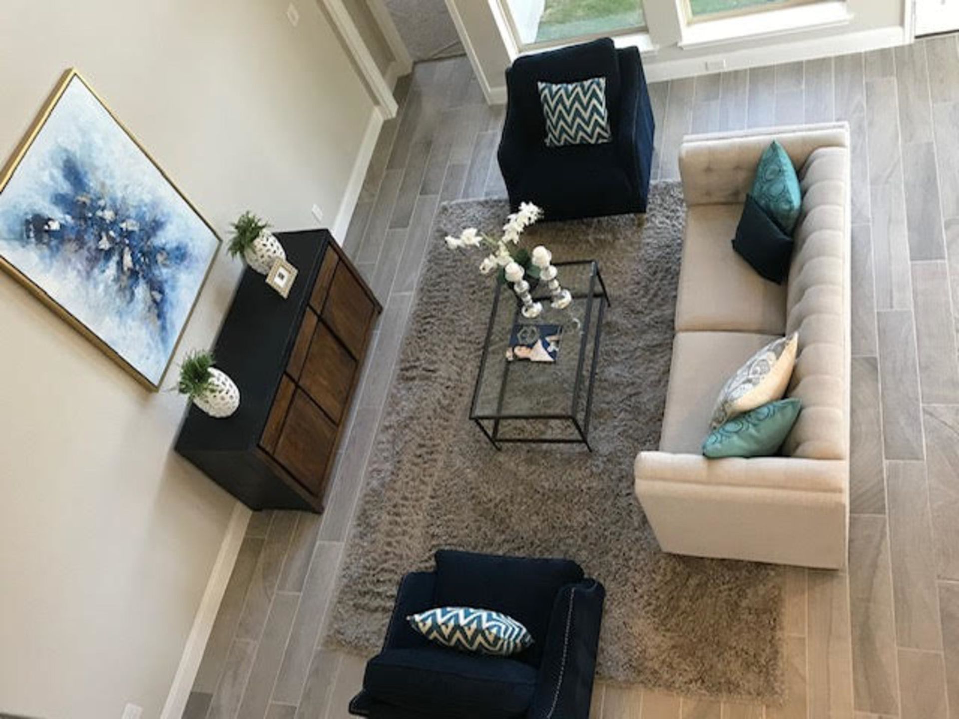 An aerial view of a living room with a couch , chairs and a coffee table.