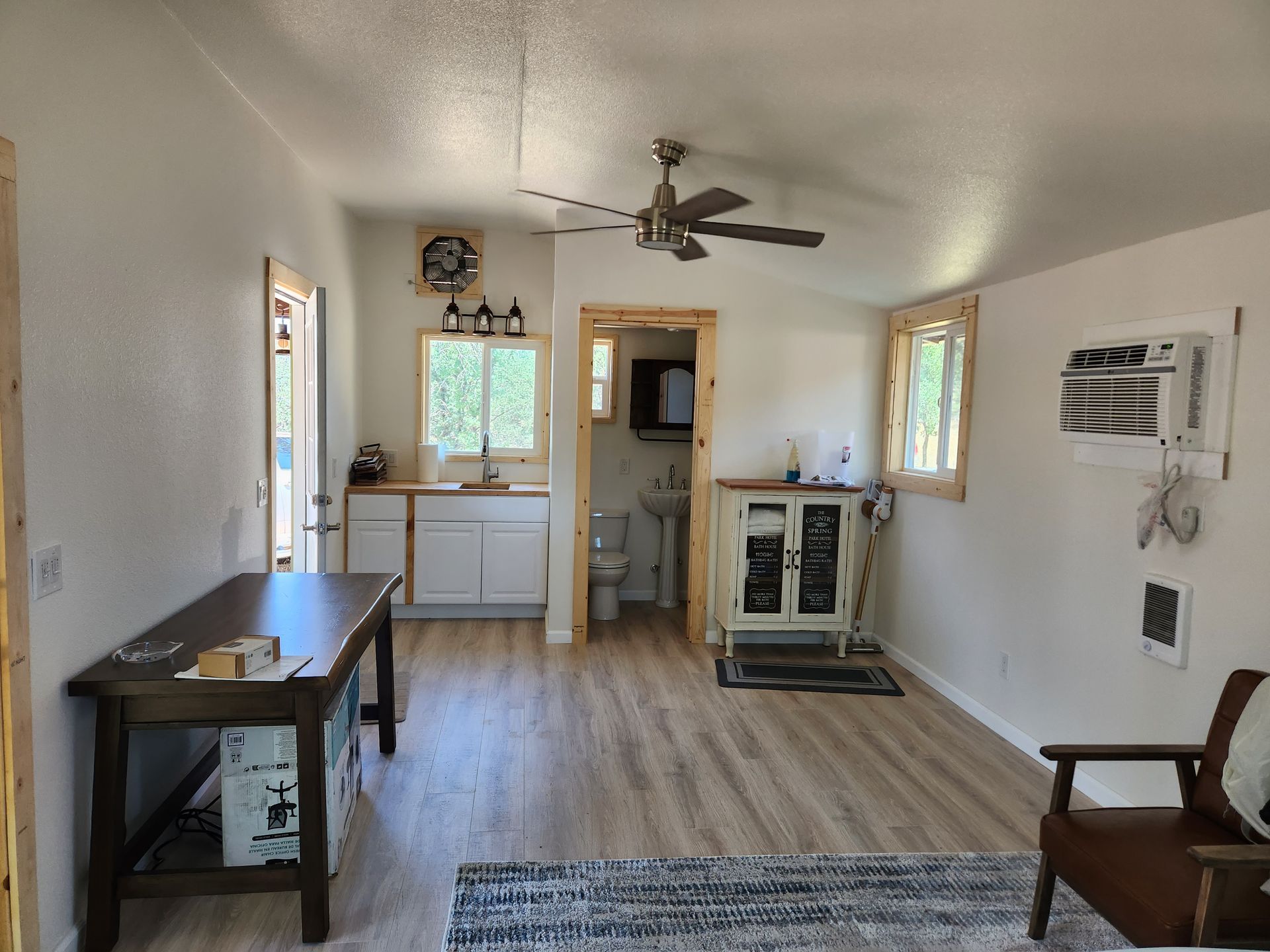 A living room with a table and chairs and a ceiling fan.