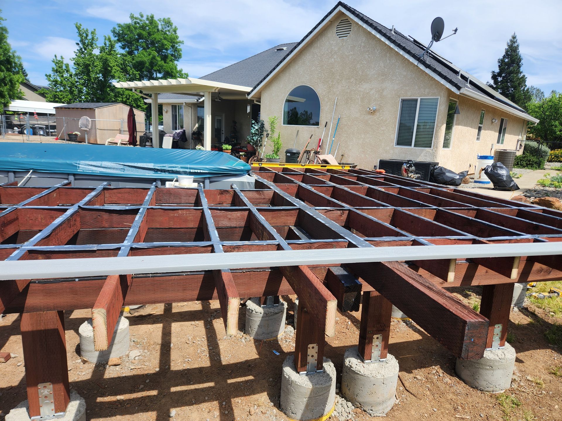 A wooden deck is being built in front of a house