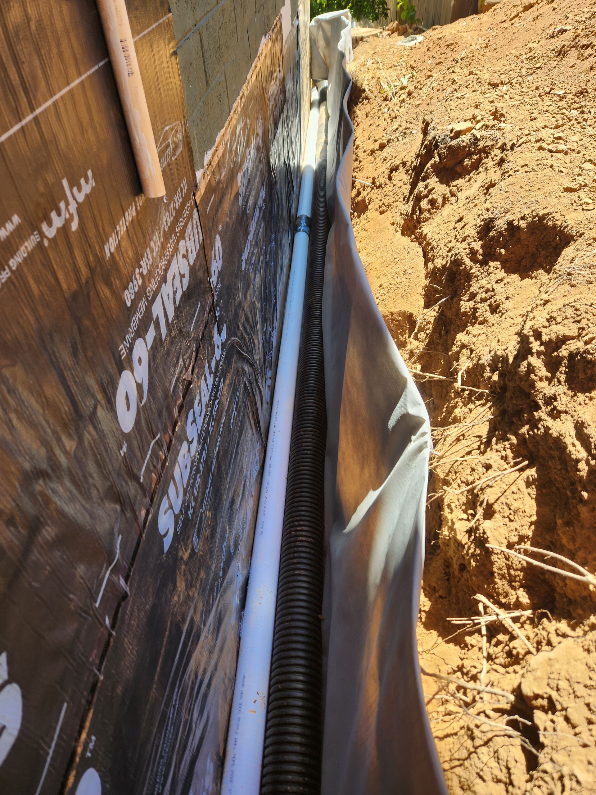 A drainage system is being installed on the side of a building.