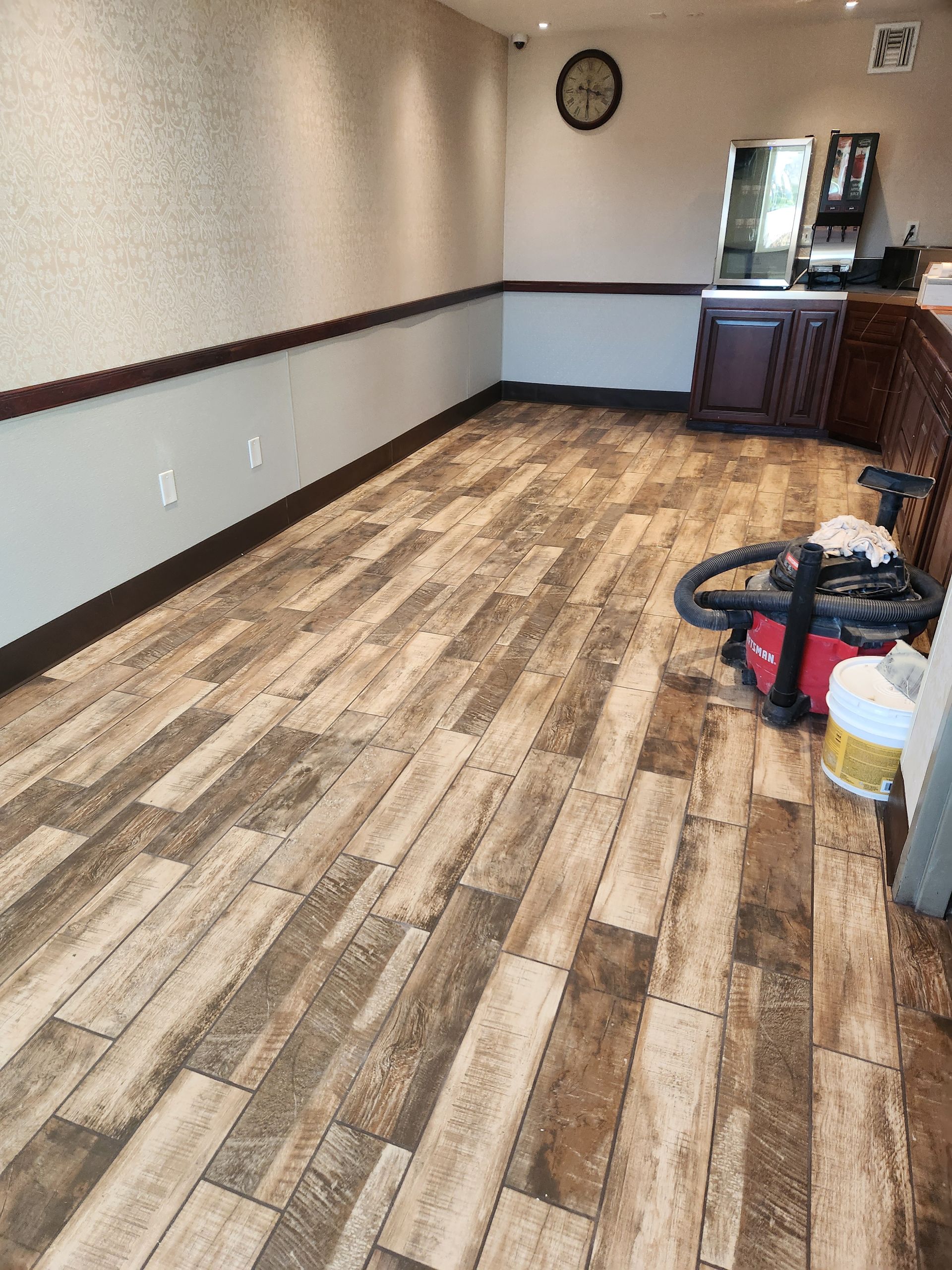 A room with a wooden floor and a vacuum cleaner in it.