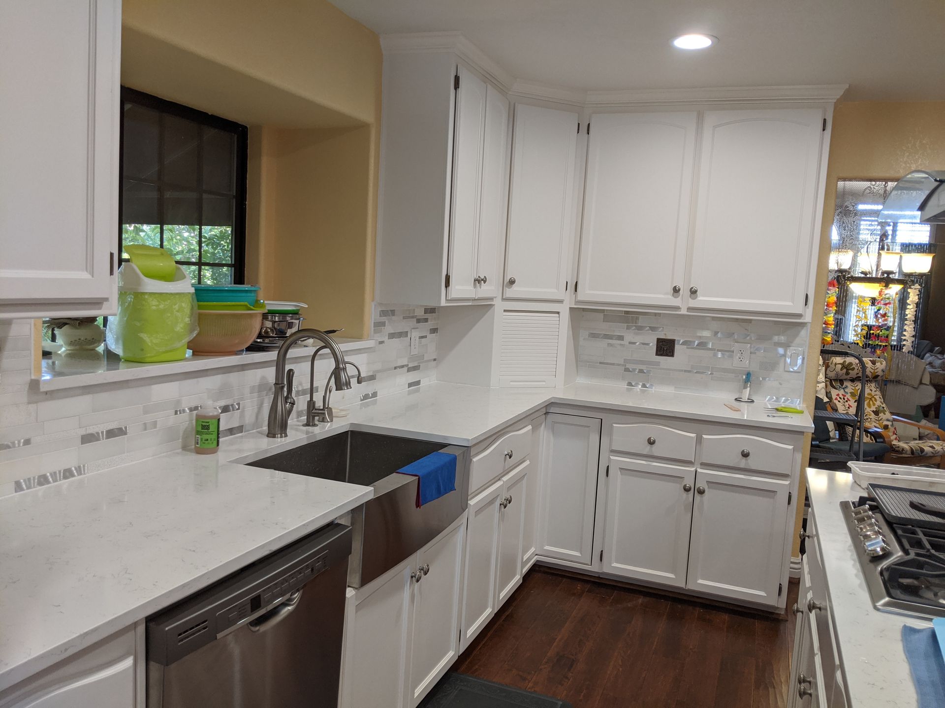 A kitchen with white cabinets and a stainless steel sink.