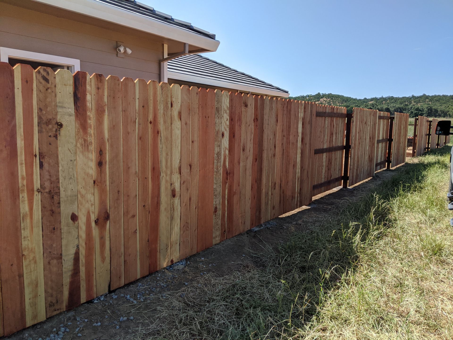 A wooden fence is sitting in front of a house.
