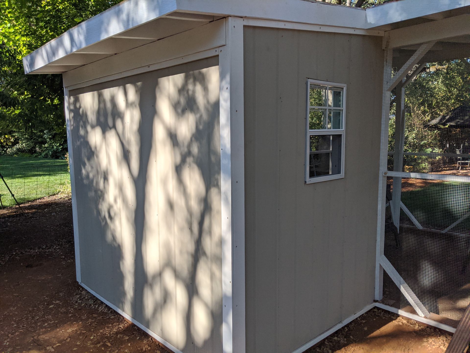 A small shed with a window on the side of it.