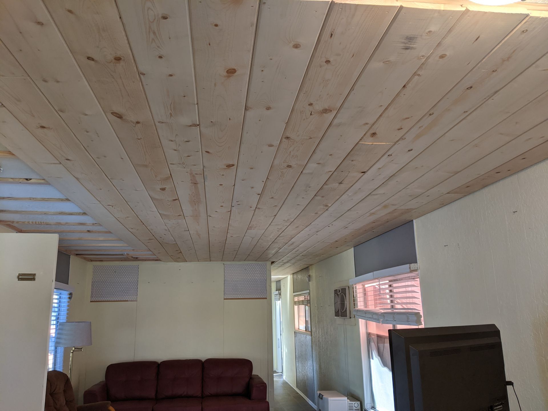 A living room with a wooden ceiling and a couch