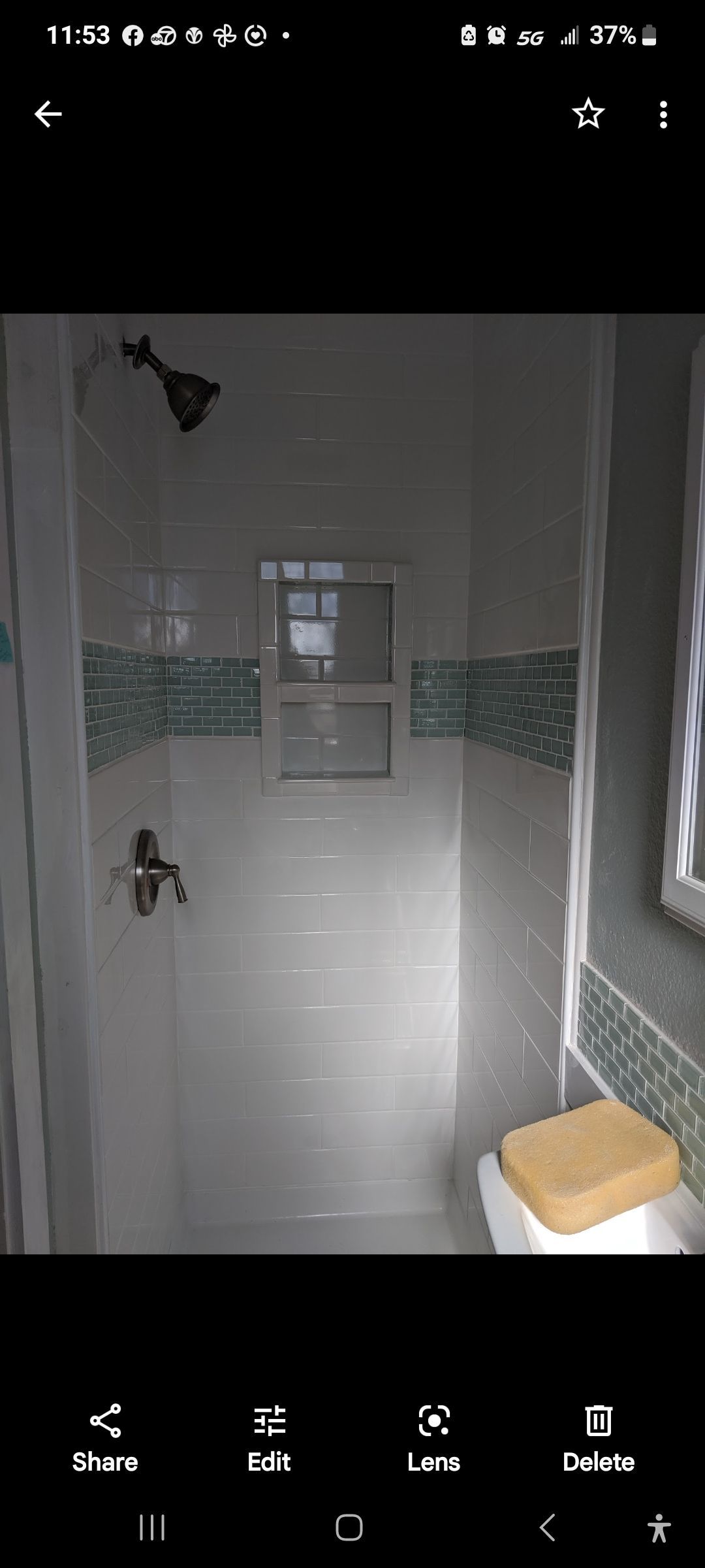 A bathroom with a shower , toilet and window.