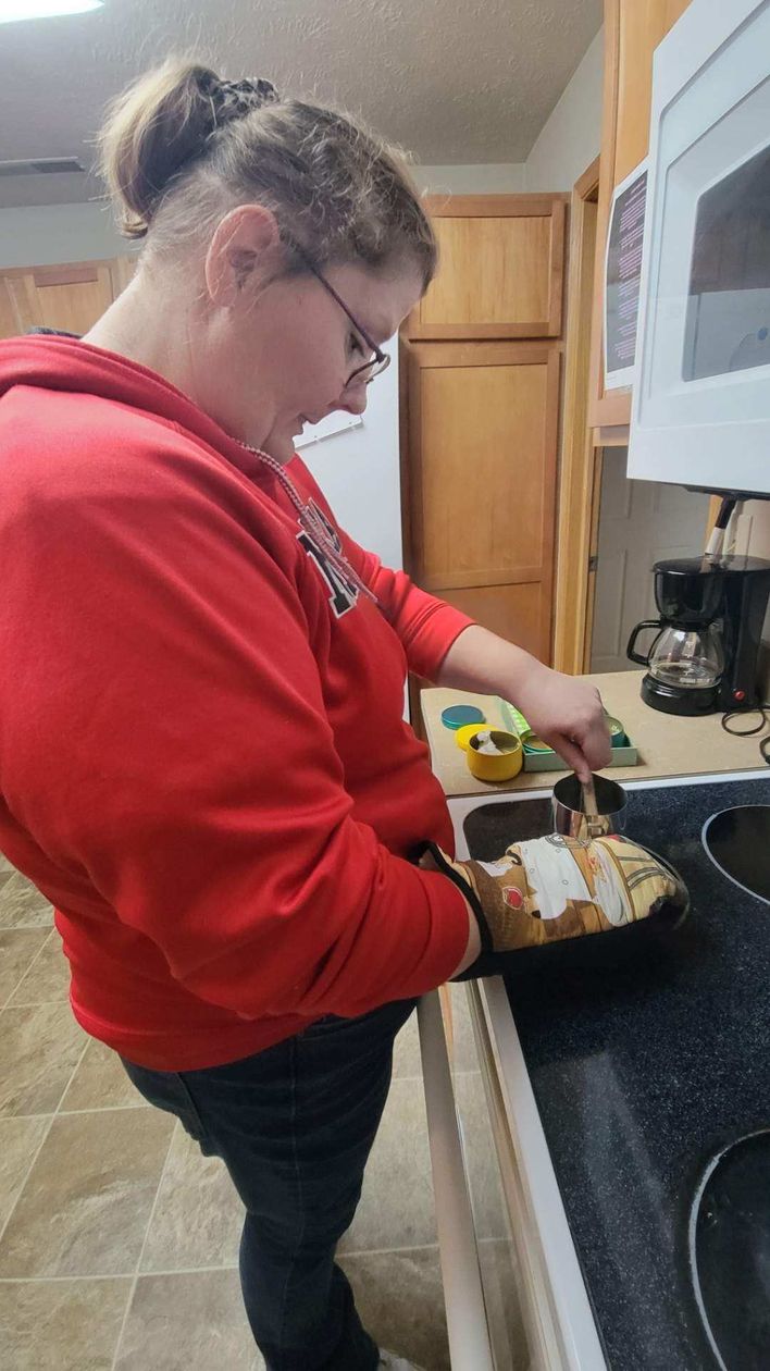 A woman in a wheelchair is being helped by a nurse in a bathroom.