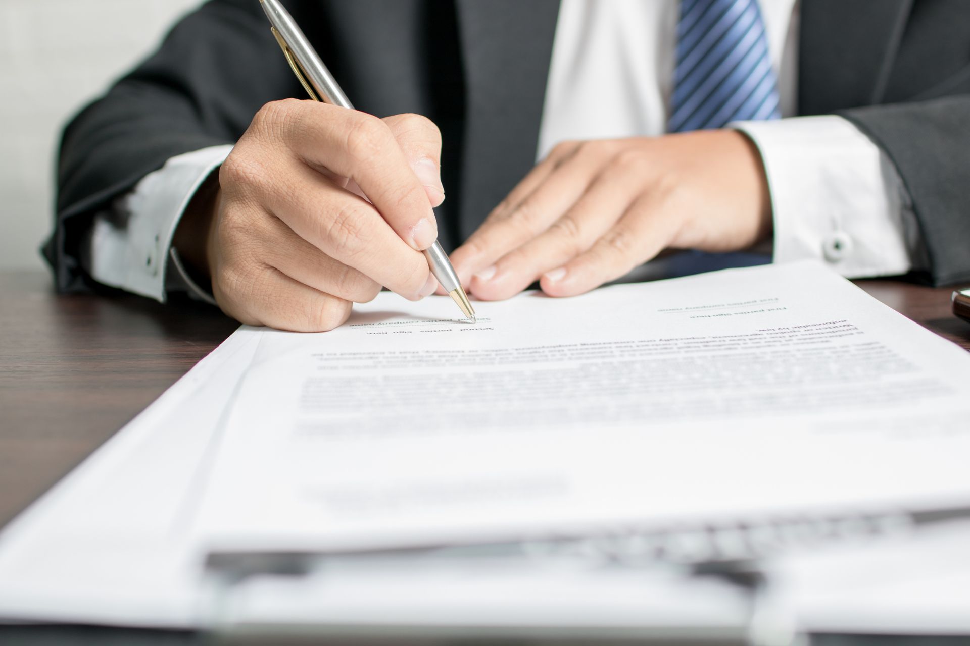 Accountant signing contract document on desk, showing accounting services in Safety Harbor, FL