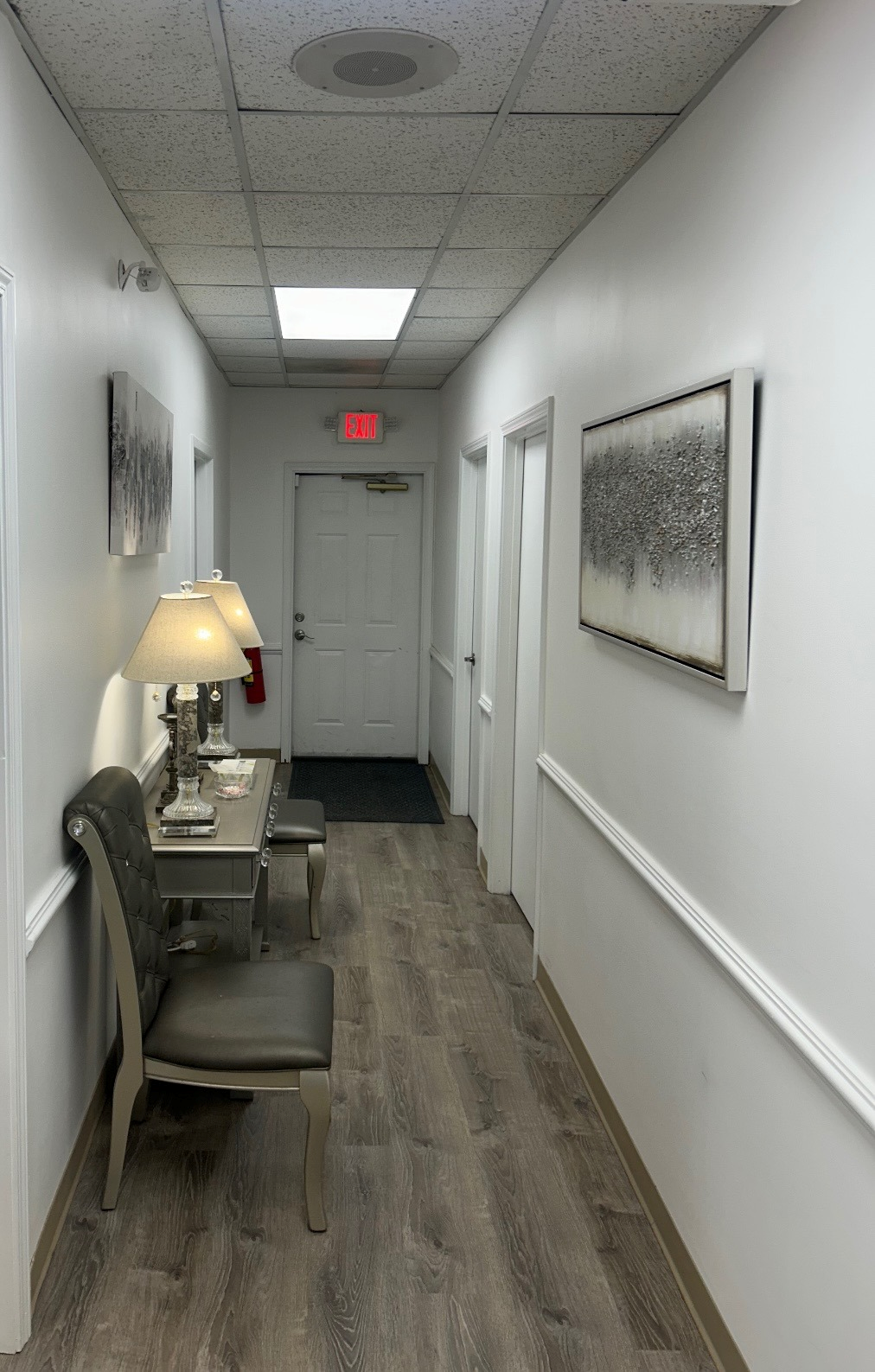 The front door of a house with a porch and plants in front of it.