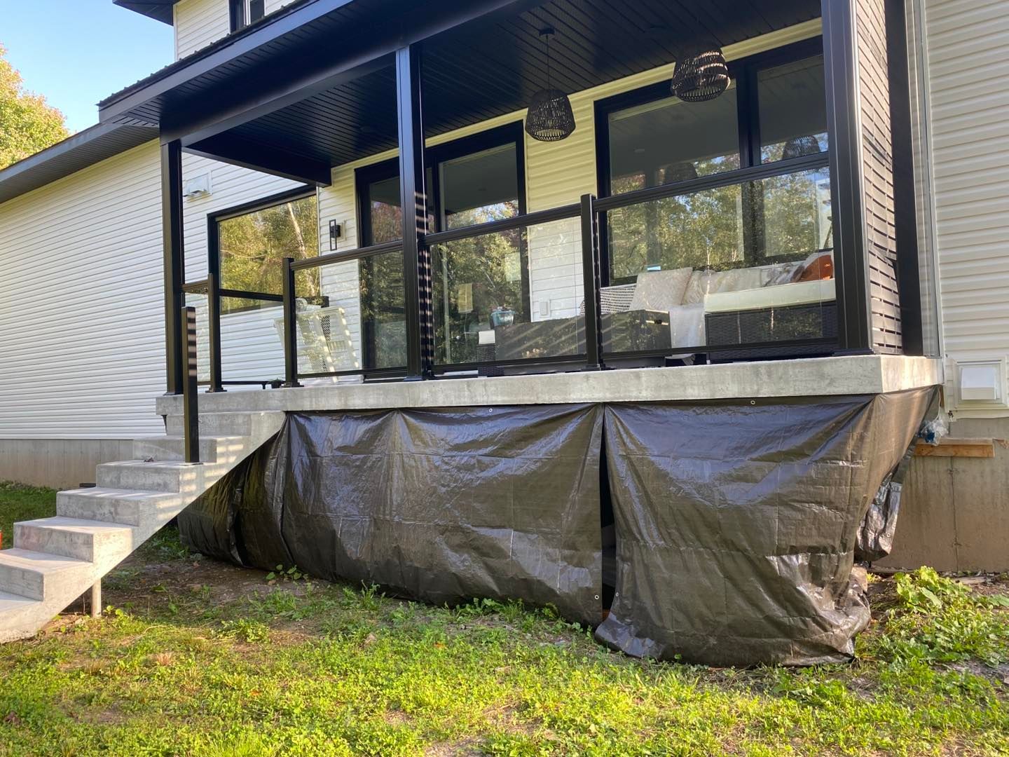 Une maison avec un porche et des escaliers recouverts d'une bâche.