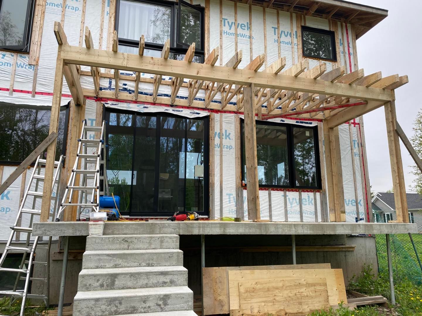 Une maison est en construction avec un porche et des escaliers.
