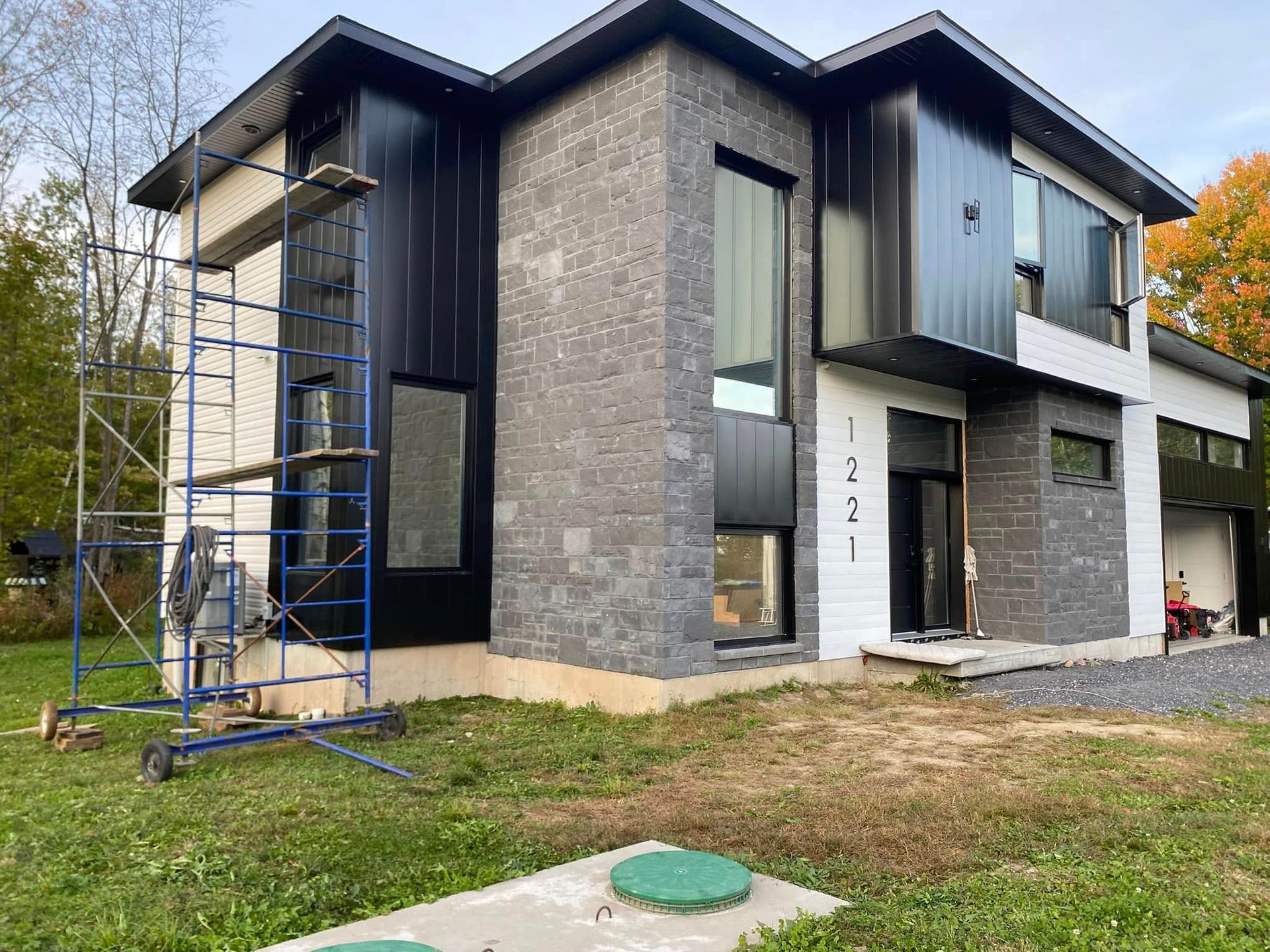 Une grande maison avec un échafaudage devant est en construction.
