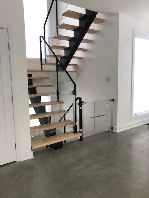 Un escalier avec des marches en bois et une rampe en verre