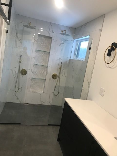 Une salle de bain avec une douche à l'italienne et un lavabo