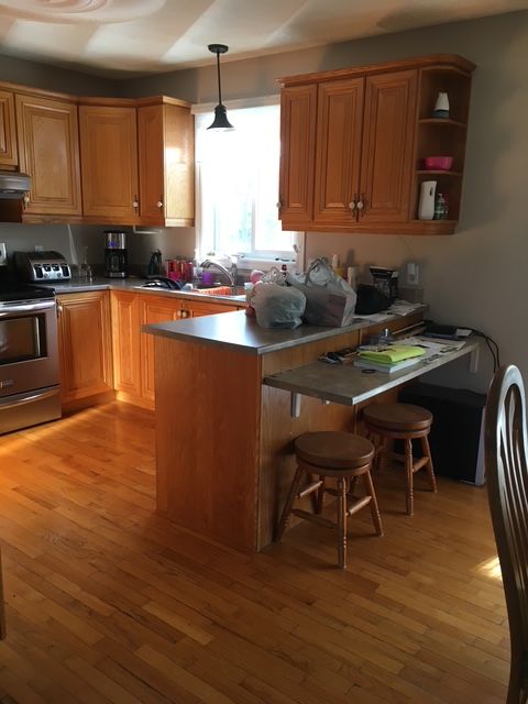 Une cuisine avec des armoires en bois et des planchers de bois franc