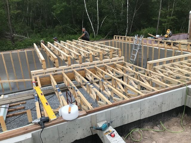 Un homme travaille sur une structure en bois dans les bois.