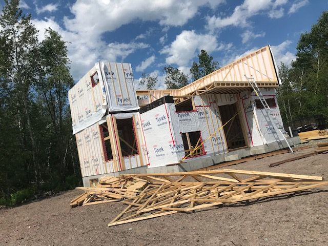 Une maison est en construction au milieu d'un champ de terre.