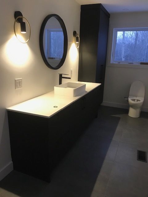 Une salle de bain avec toilettes, un lavabo et deux miroirs