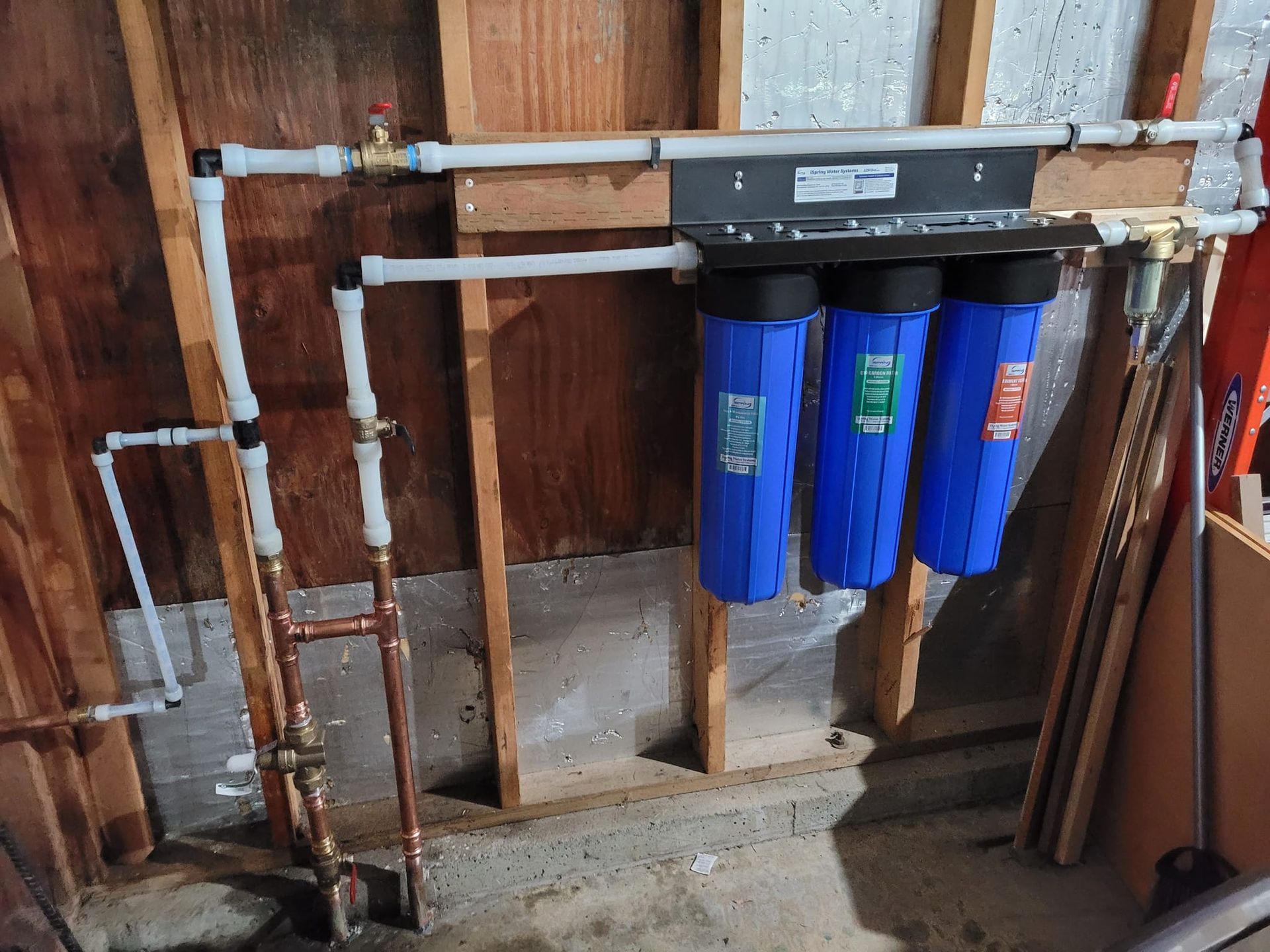 A water filter is hanging on a wall in a garage.