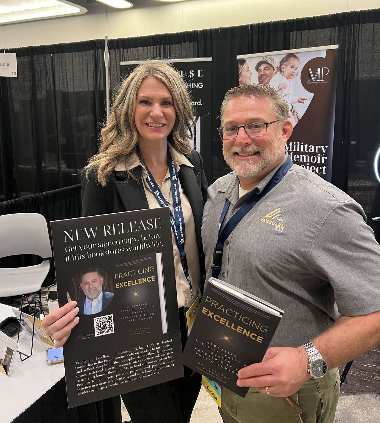 A man and a woman are standing next to each other holding books.