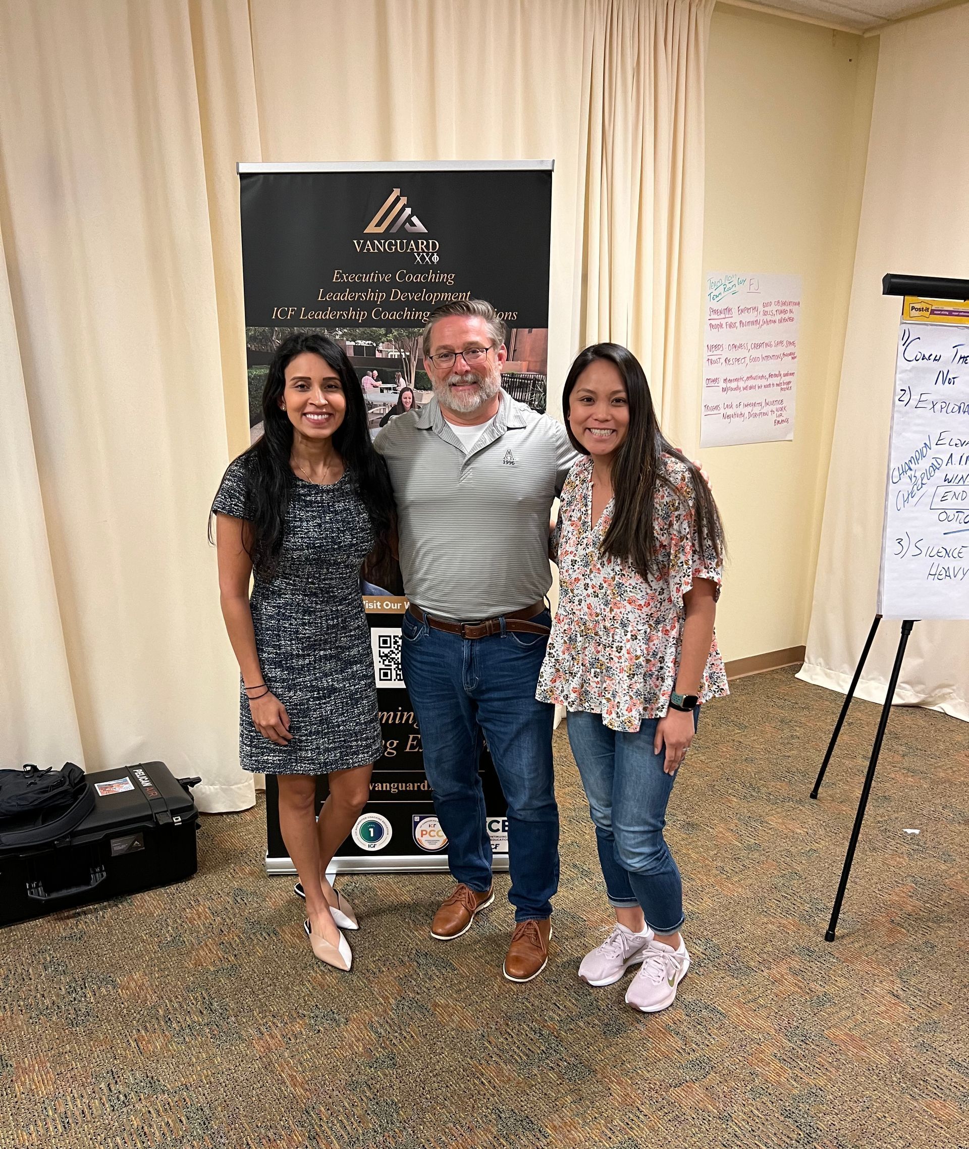 A man and two women are posing for a picture in a room.