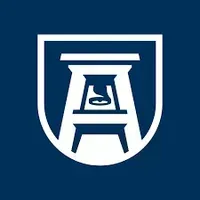 A white stool in a shield on a blue background.