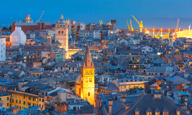 An aerial view of a city at night with a clock tower in the middle of the city.