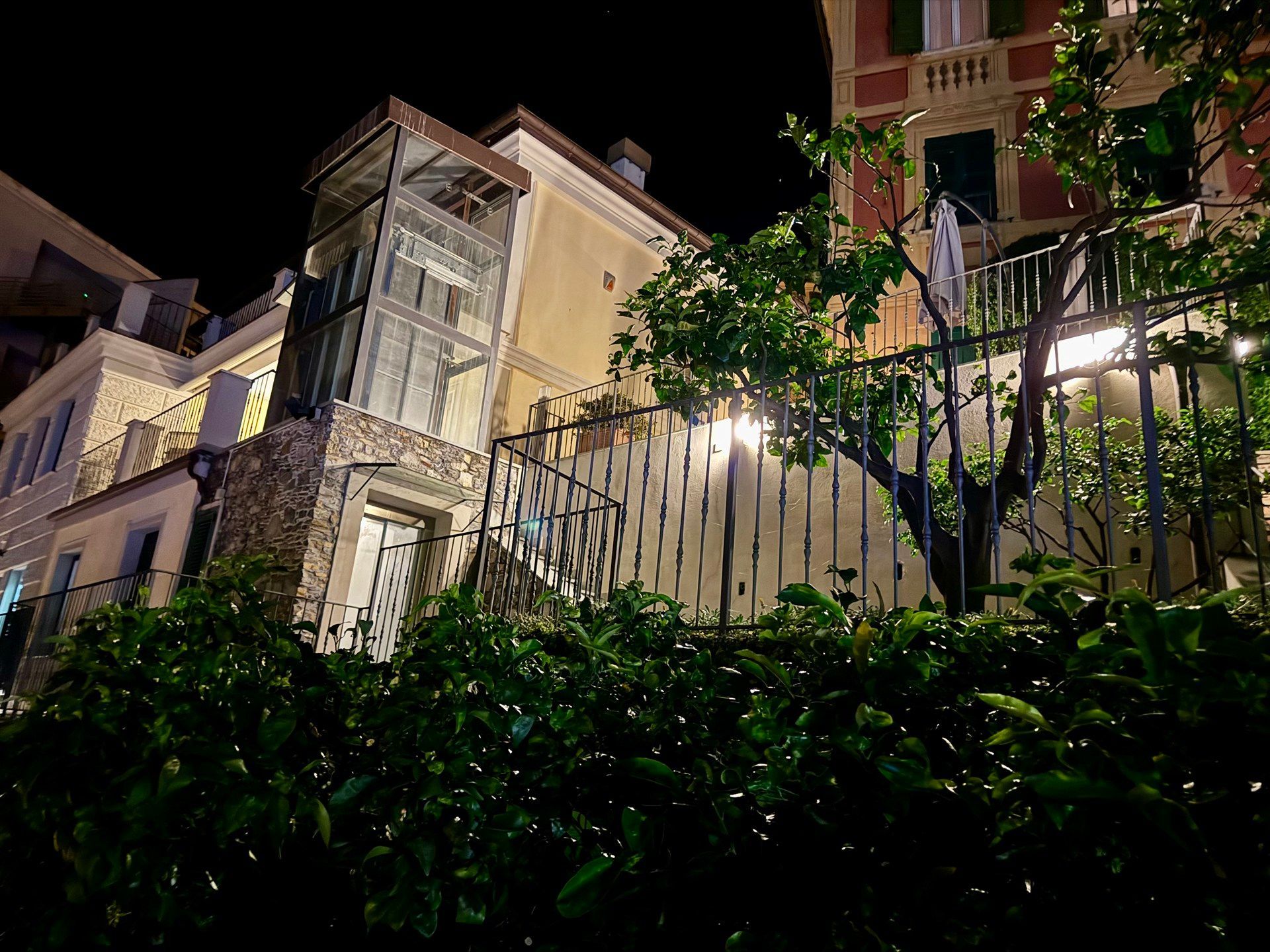 A large building with a fence around it is lit up at night.