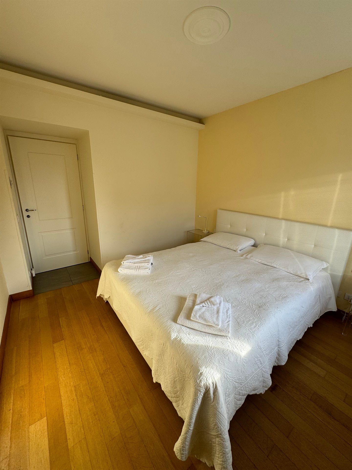A bedroom with a large bed and a door.