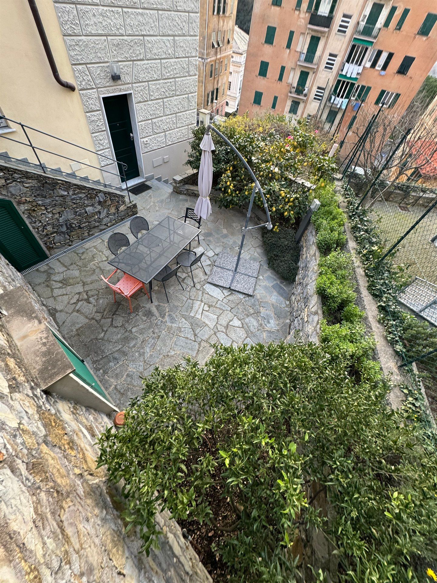 An aerial view of a patio with a table and chairs in front of a building.