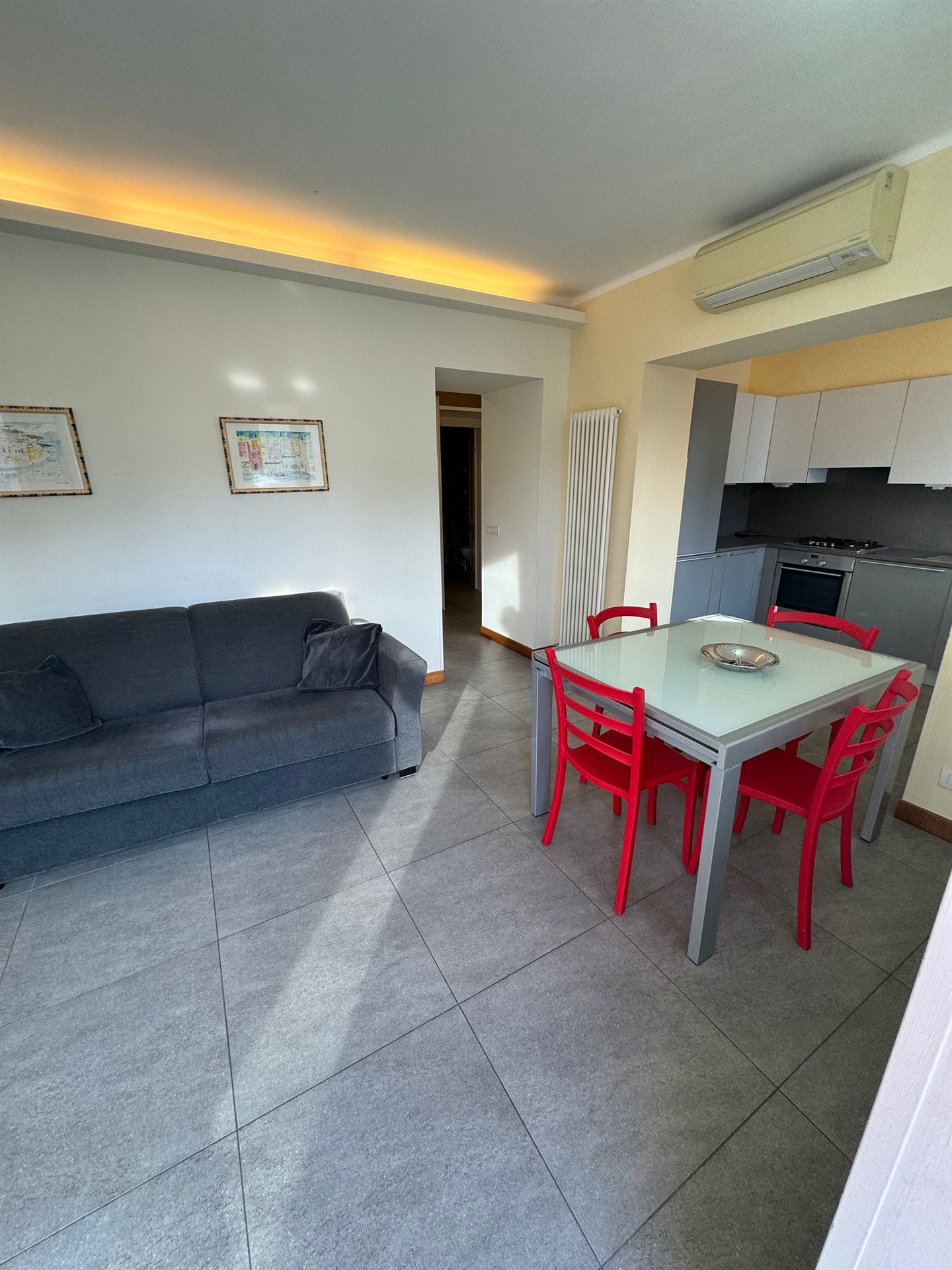 A living room with a couch , table and chairs.