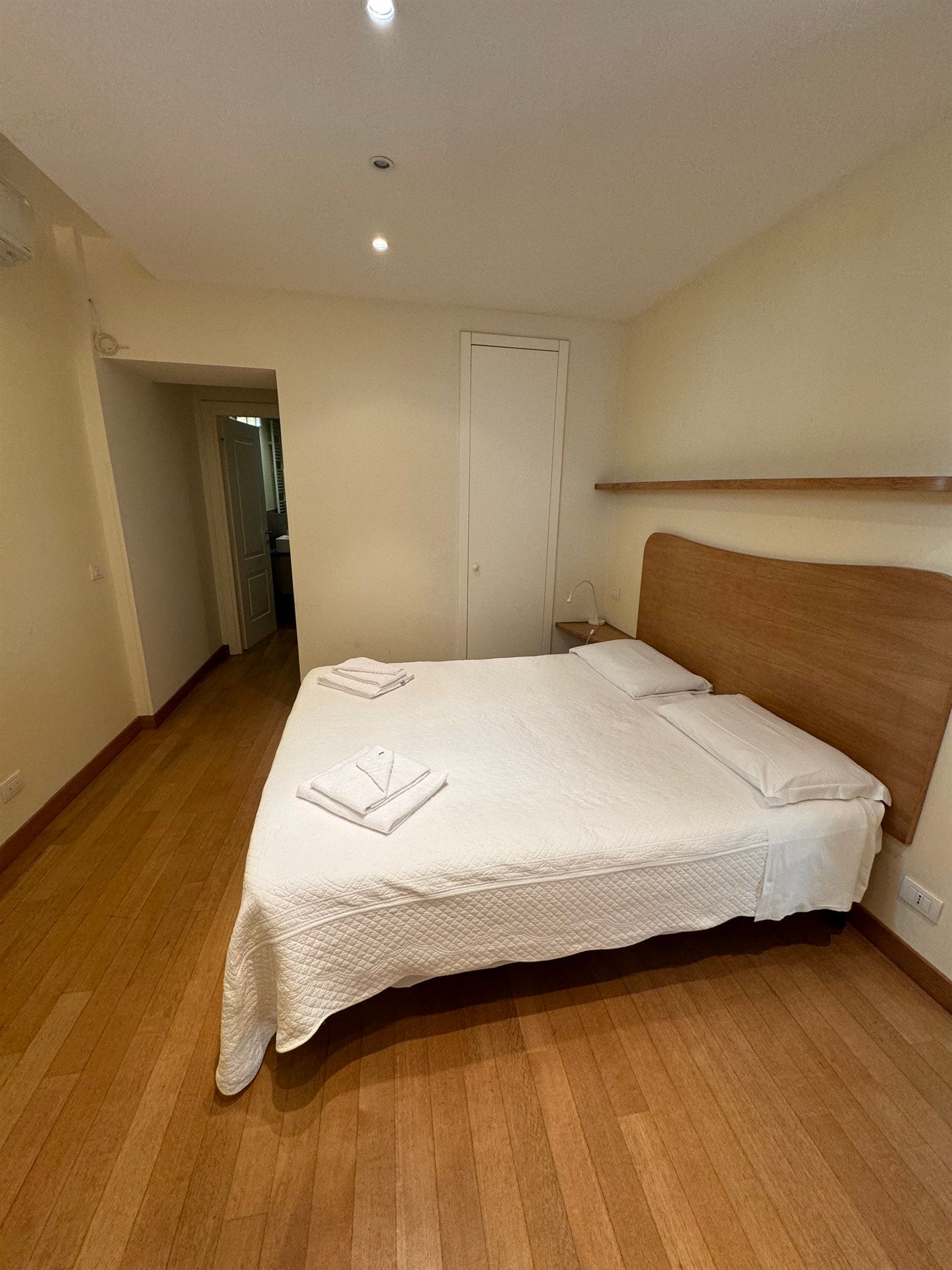 A bedroom with a large bed and wooden floors