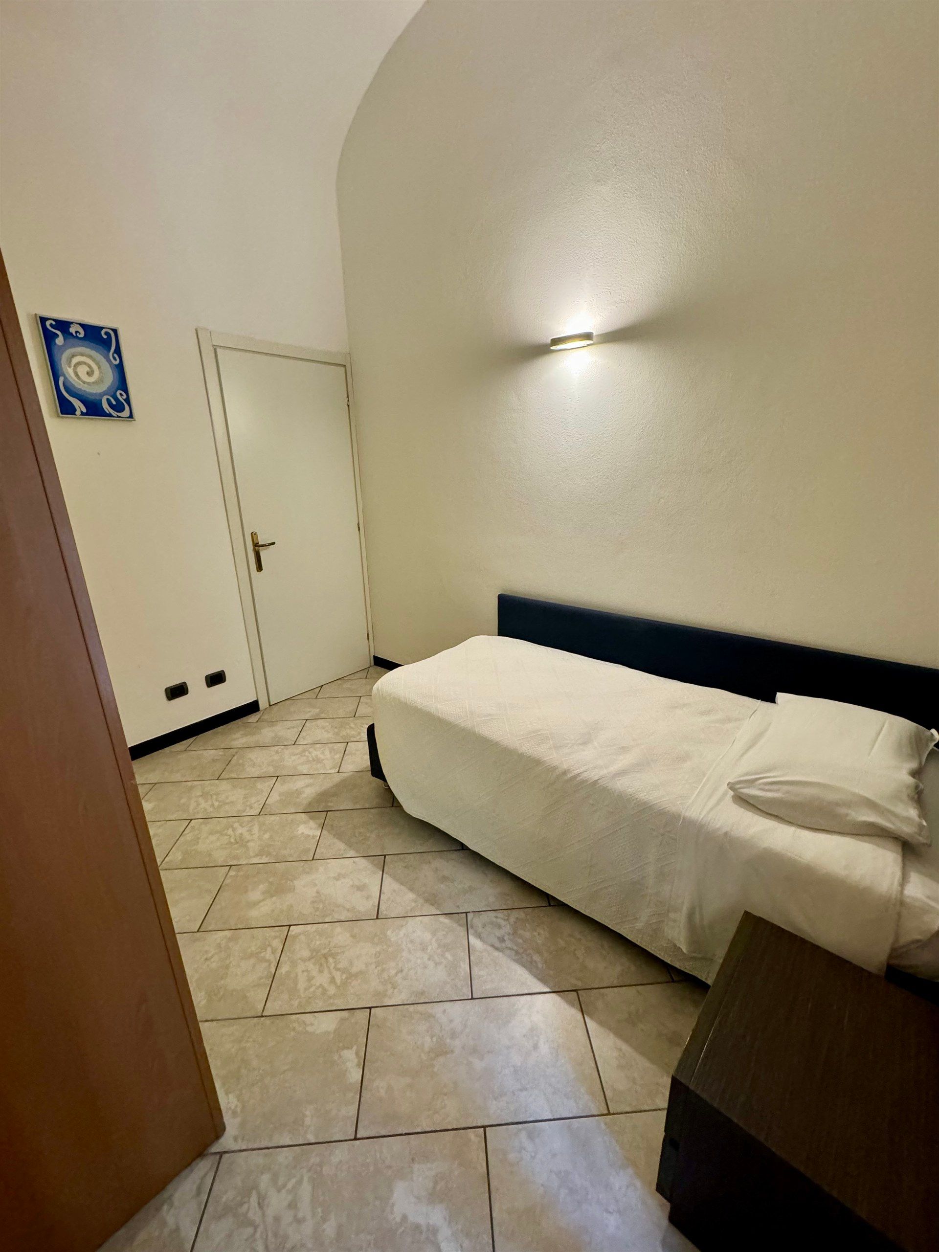 A bedroom with a single bed and a door.