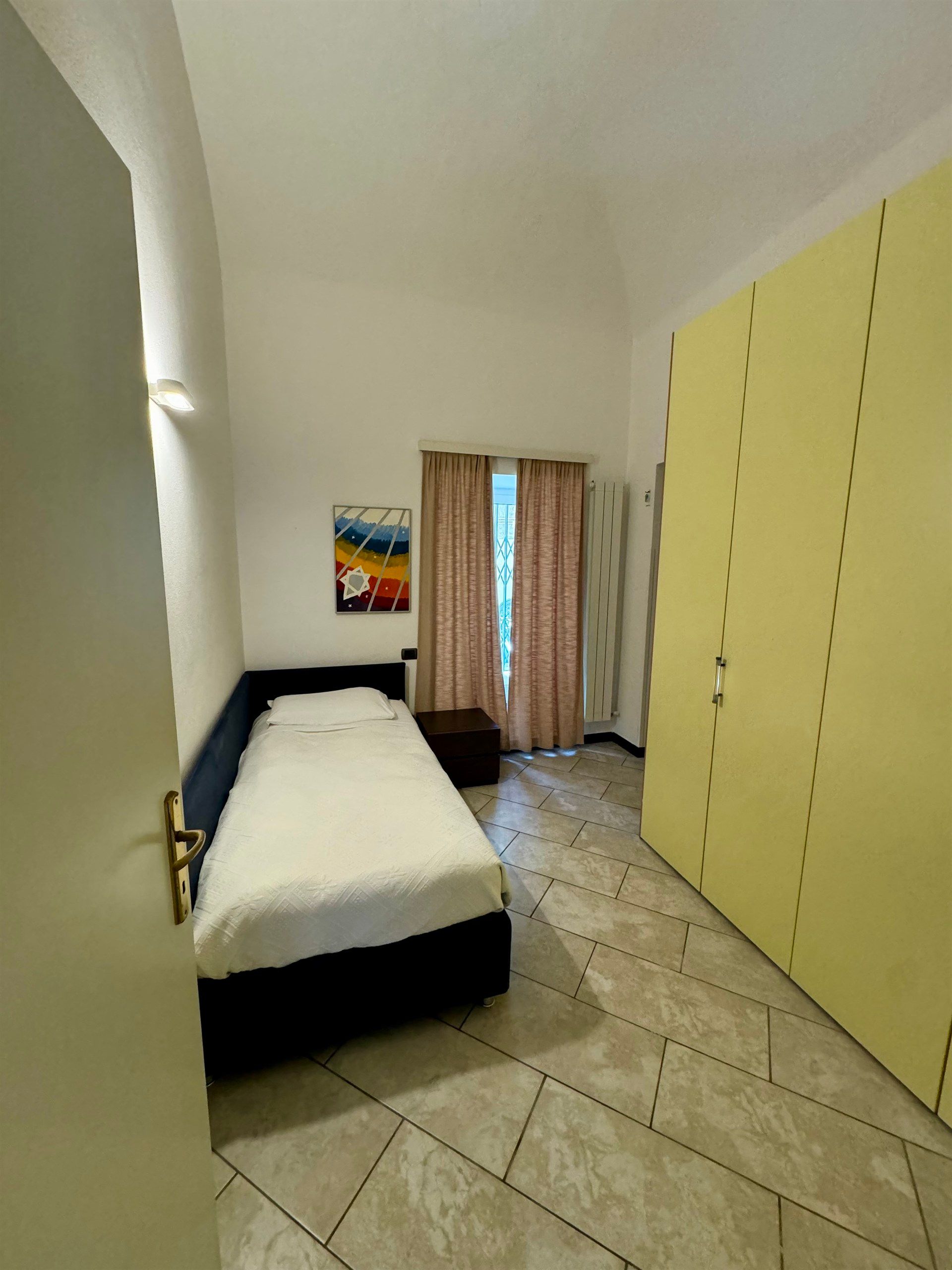 A bedroom with a single bed and yellow walls