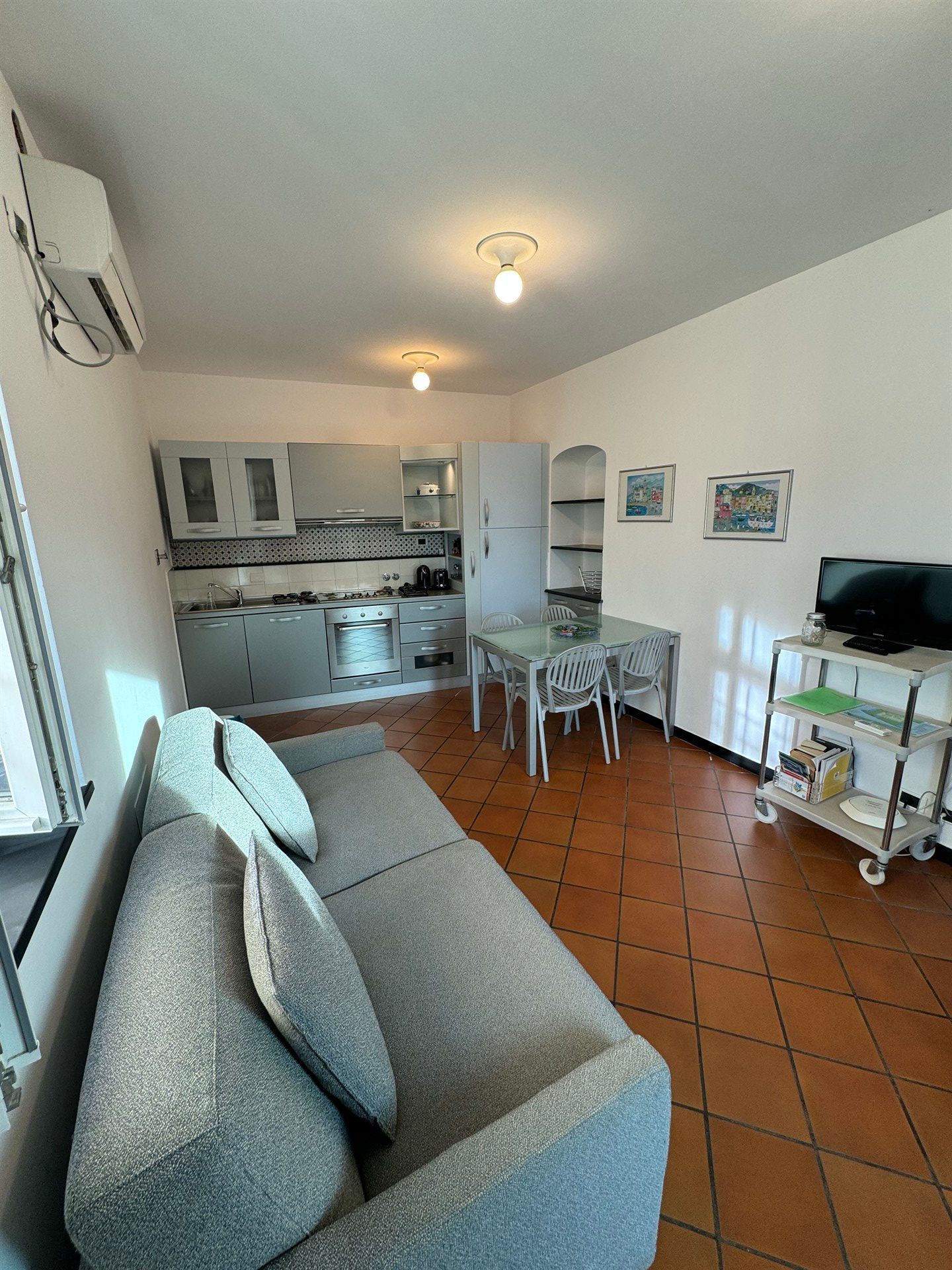 A living room with a couch , table and chairs.