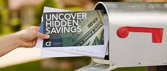 A person is putting a flyer in a mailbox that says `` uncover hidden savings ''.