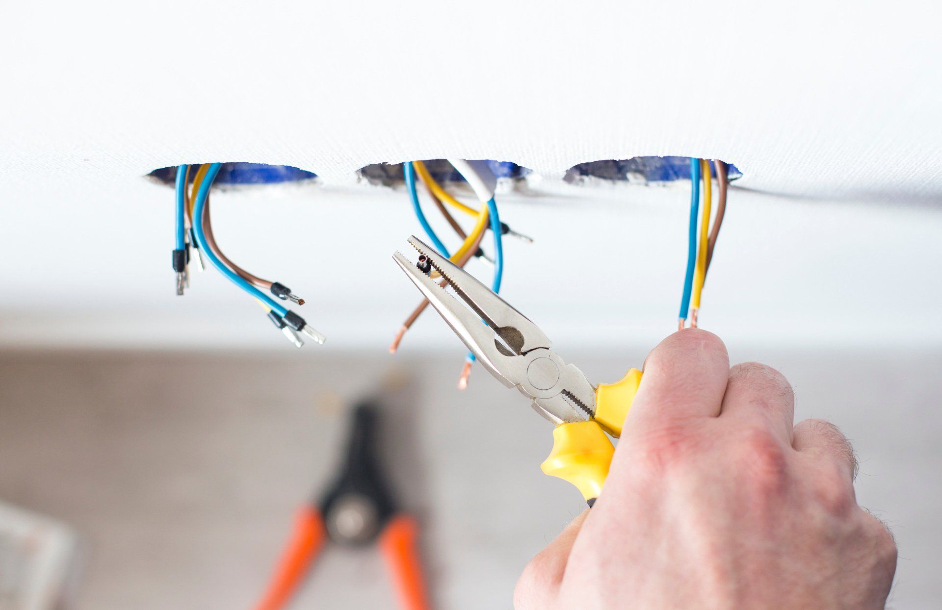 A person is cutting a wire with a pair of pliers.