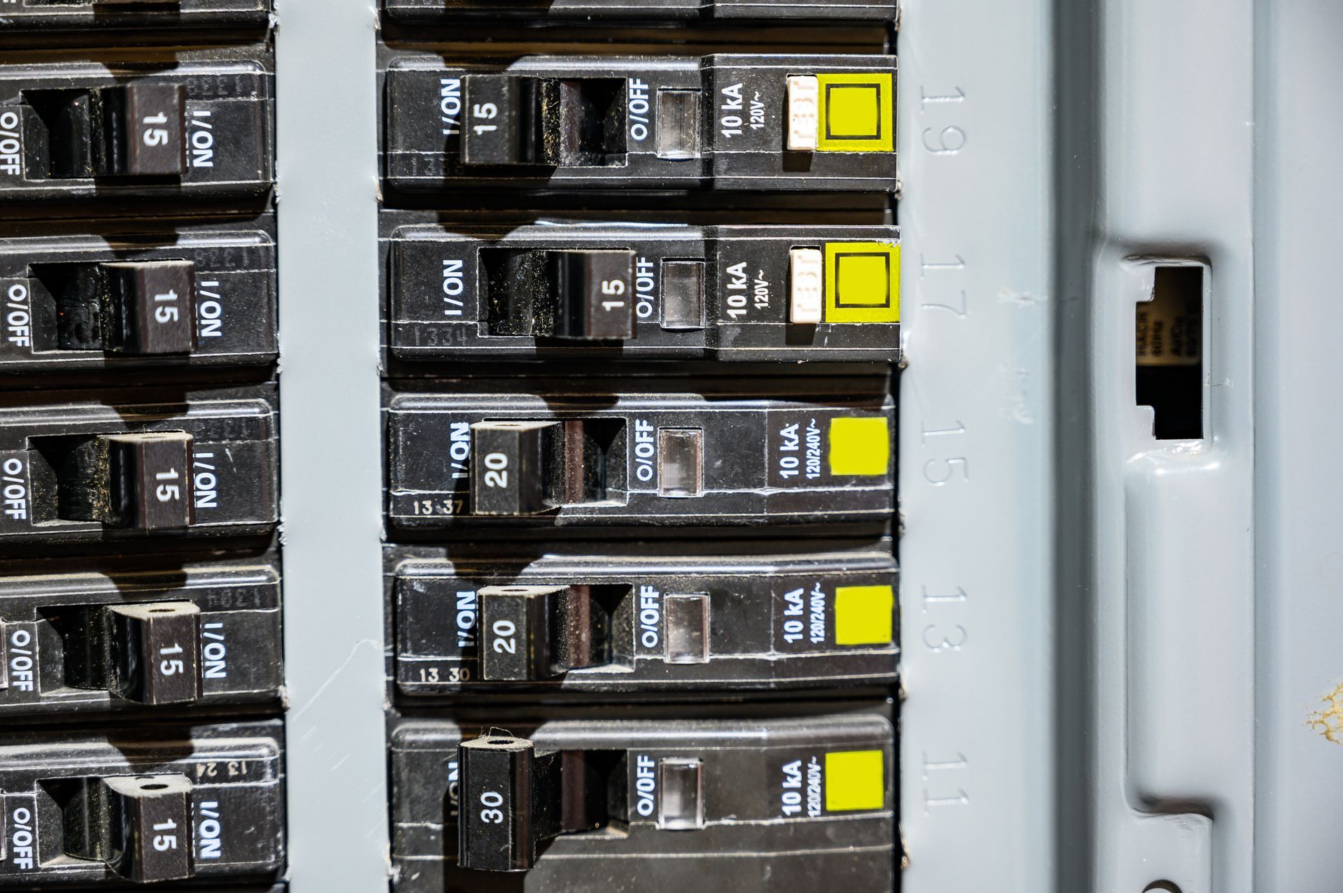 A close up of a electrical panel with a lot of electrical breakers.