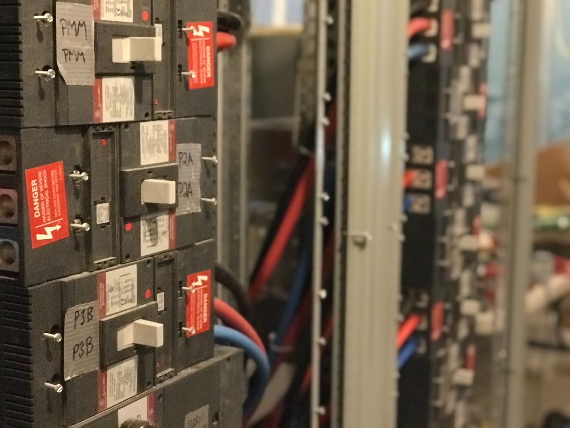 A close up of a electrical panel with a lot of wires coming out of it.